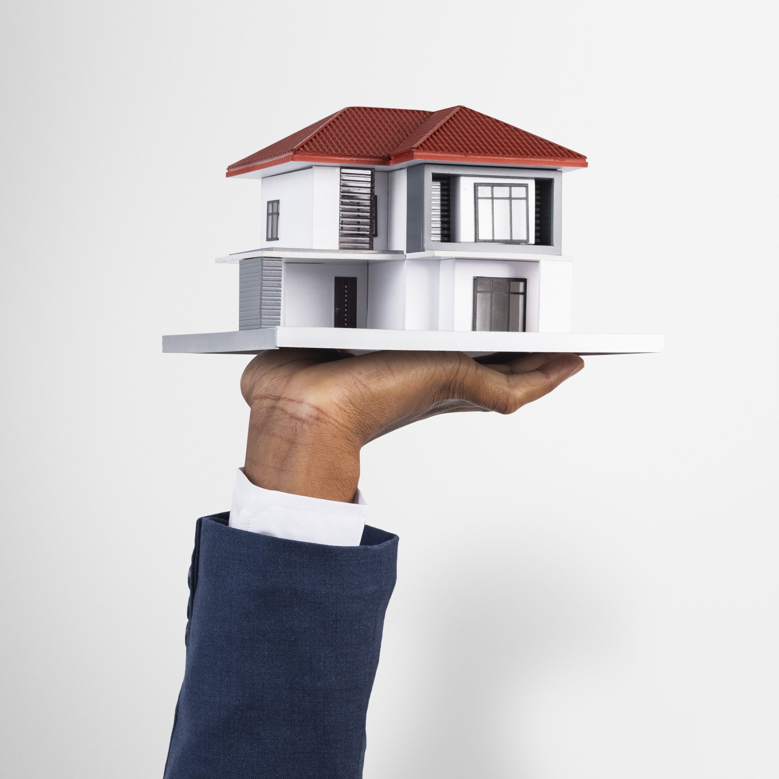 hand-holding-house-real-estate-property-model-scaled